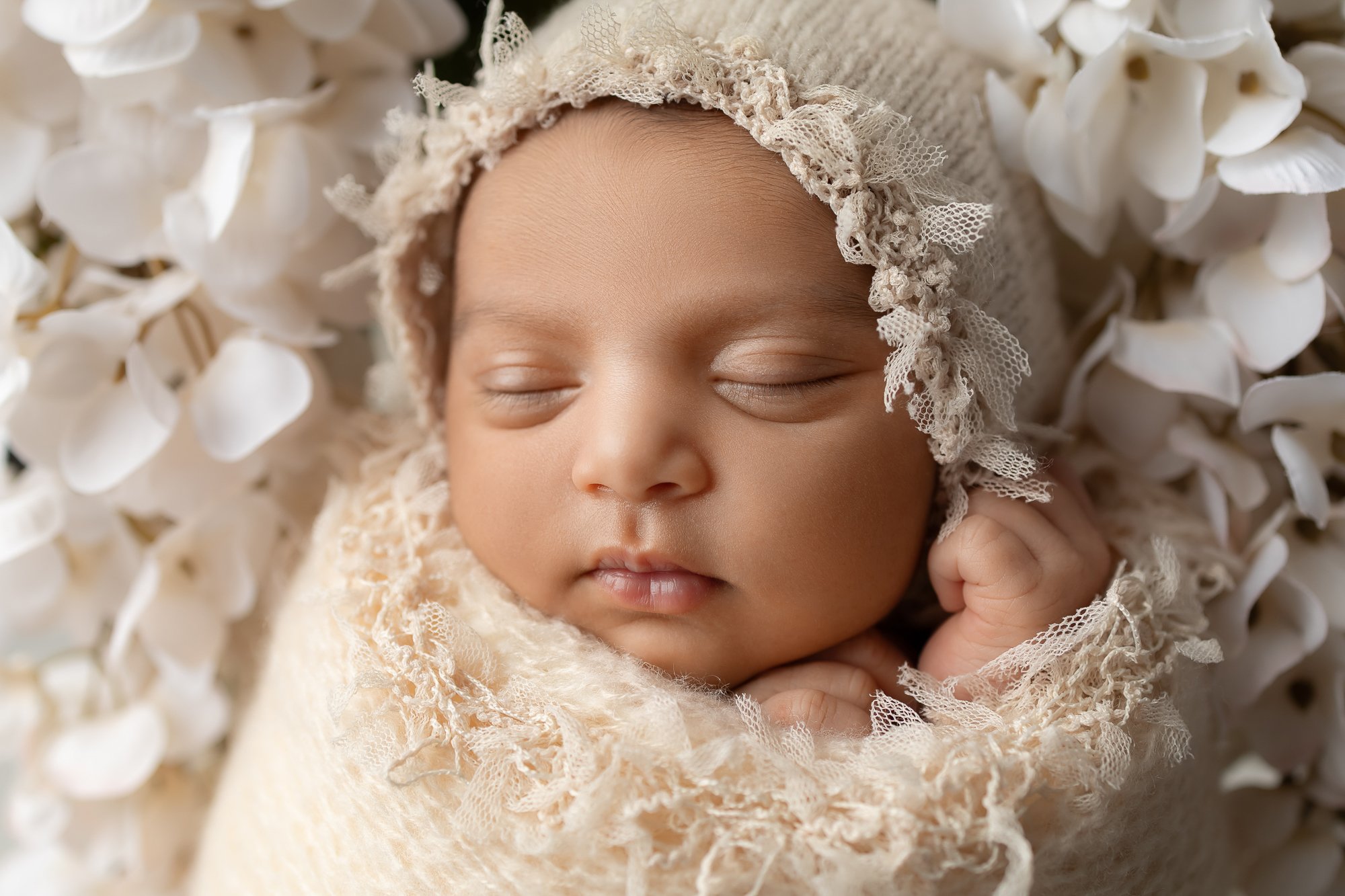 Newborn close-up in cream lace wrap and crocheted bonnet with white hydrangeas — IDTPhoto Aurora IL newborn photographer