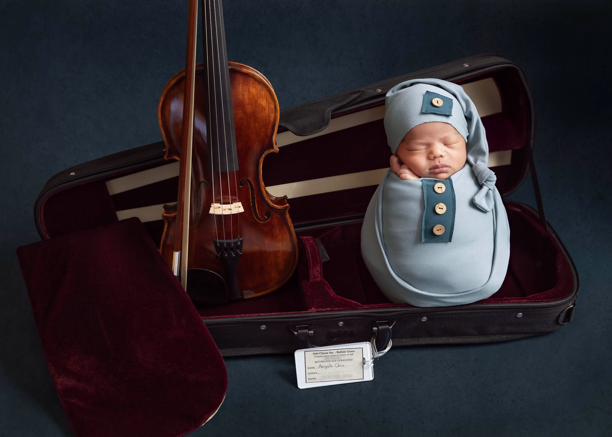Newborn in blue sleep sack nestled in violin case with personalized prop — IDTPhoto Chicagoland newborn photographer