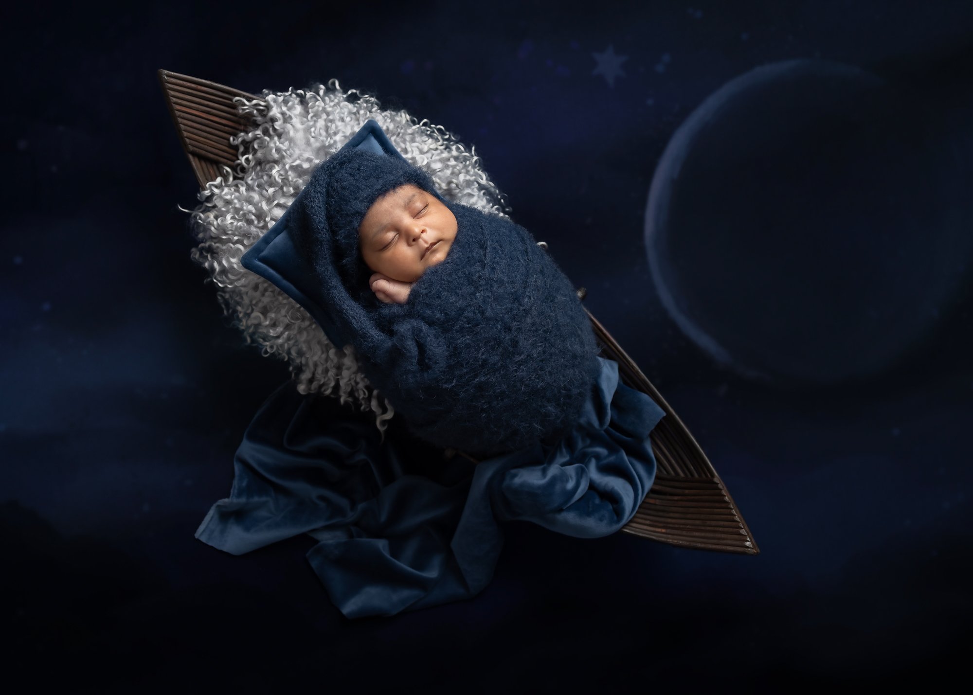Newborn in navy wrap in star-shaped prop with galaxy background — IDTPhoto Aurora IL creative newborn photography
