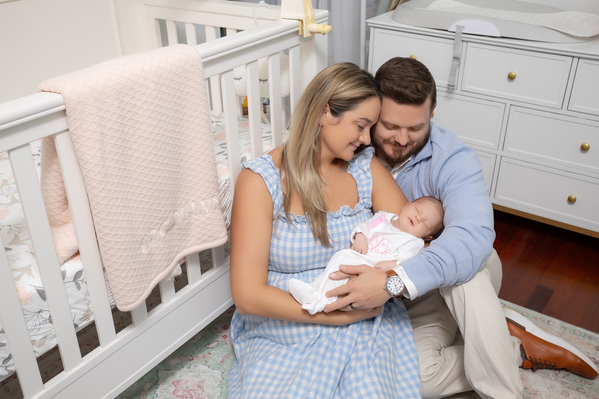 Parents sitting on nursery floor together gazing at sleeping newborn — IDTPhoto Chicagoland lifestyle newborn photography