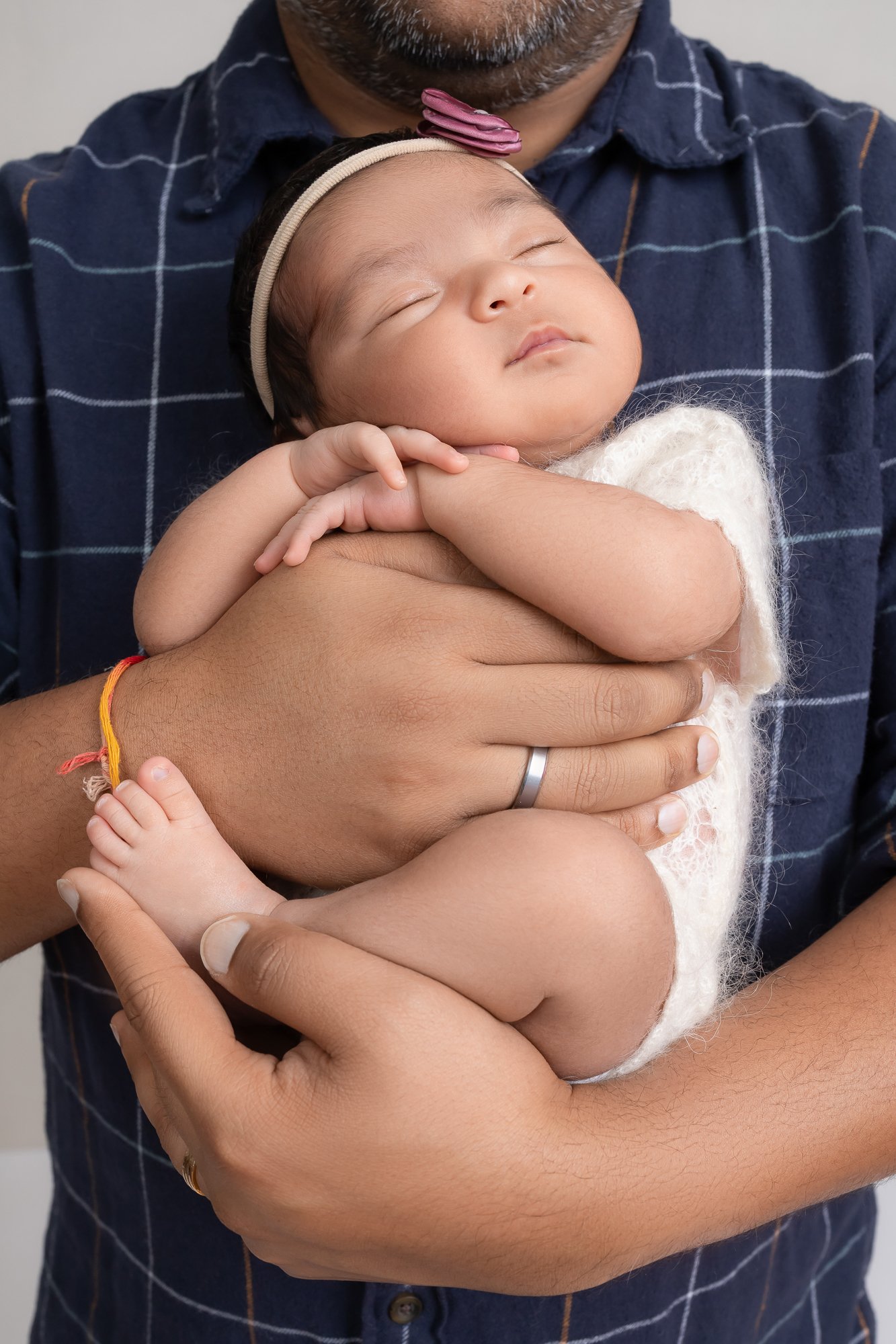 Close-up of father cradling sleeping newborn in studio — IDTPhoto Aurora IL newborn photographer