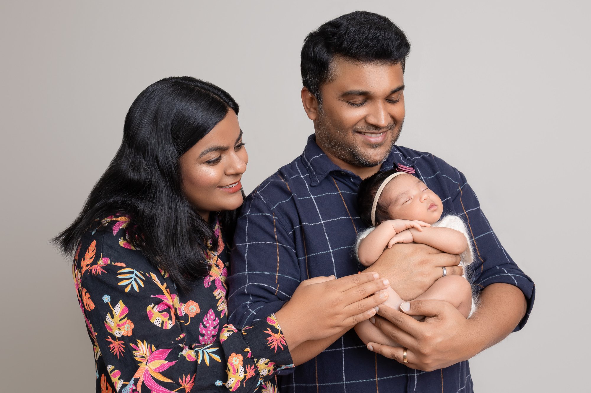 Mother and father gazing down at sleeping newborn in studio — IDTPhoto Chicagoland newborn photography